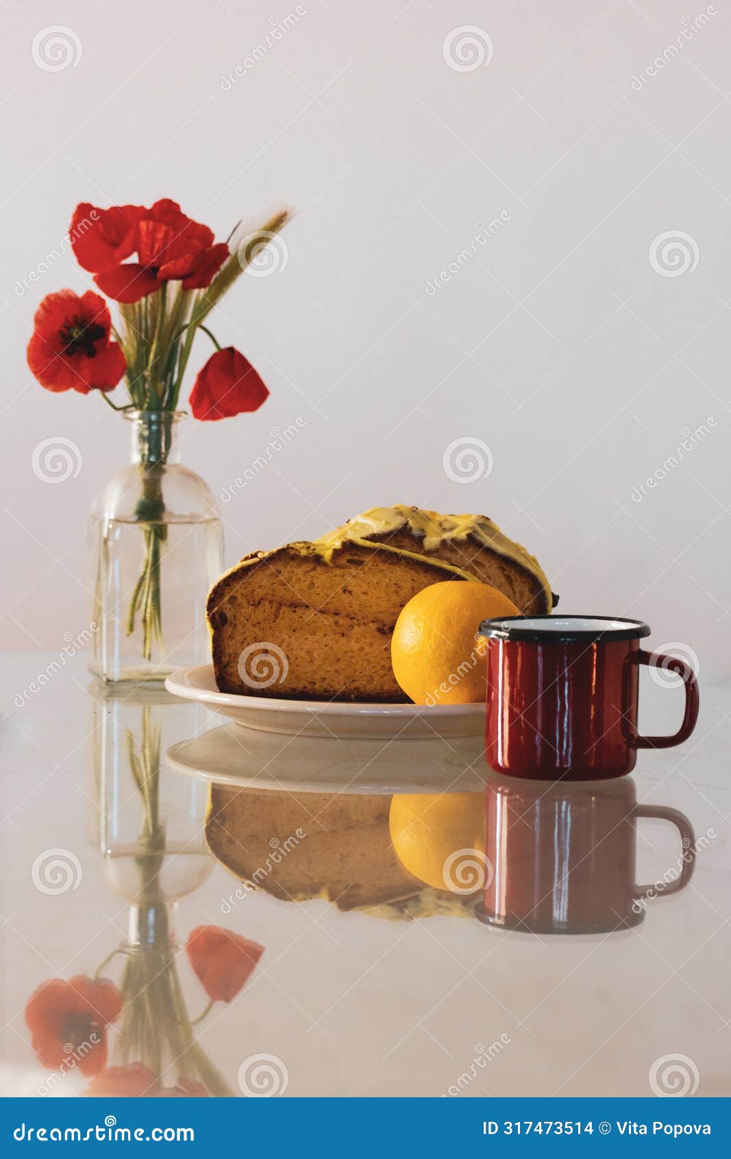 rural still life with red poppies in glass vase and a plate with biscocho bizcocho lemon muffin on kitchen table. sweet