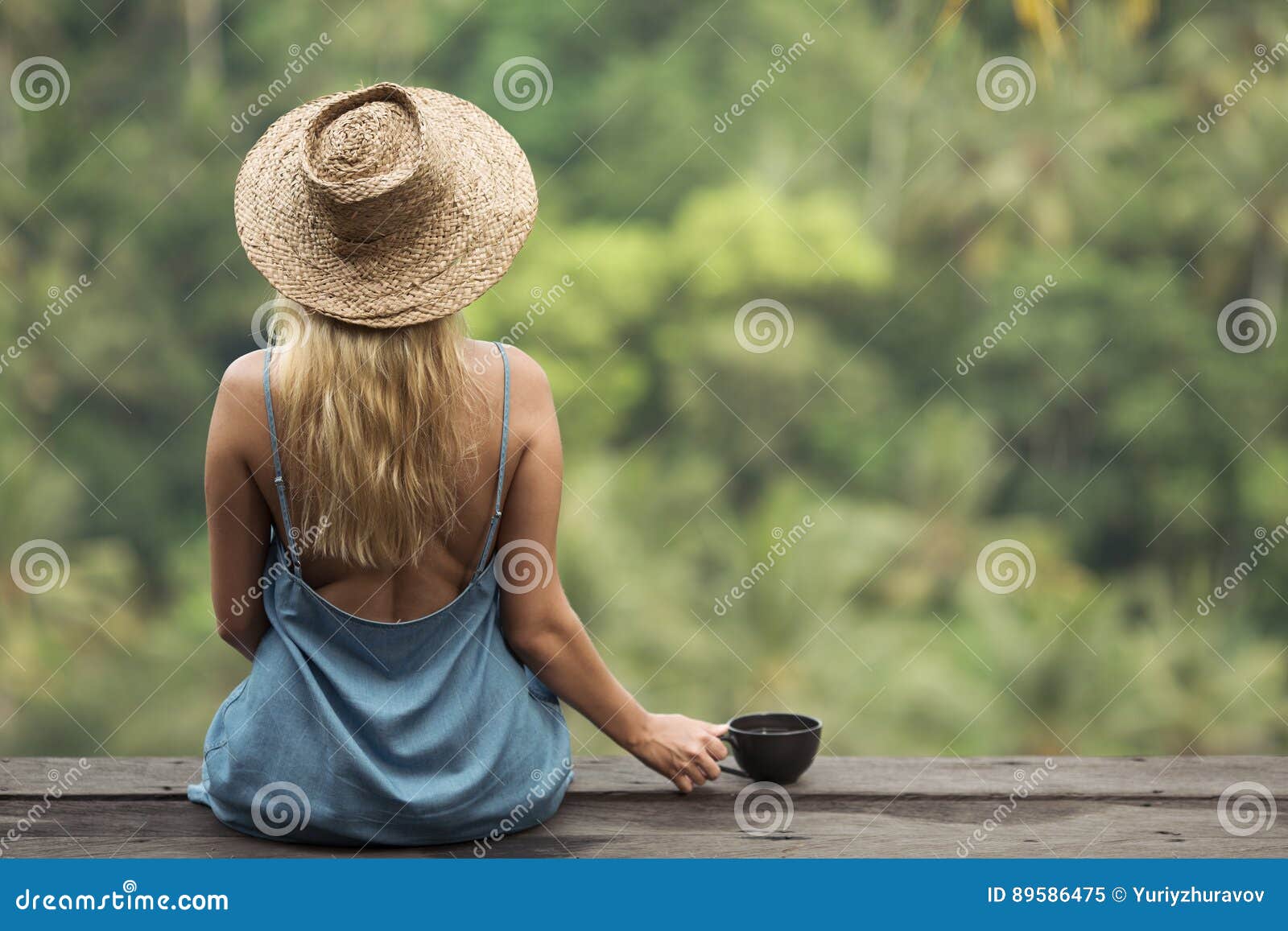 rural woman with cup of coffee siting and look on jungle.