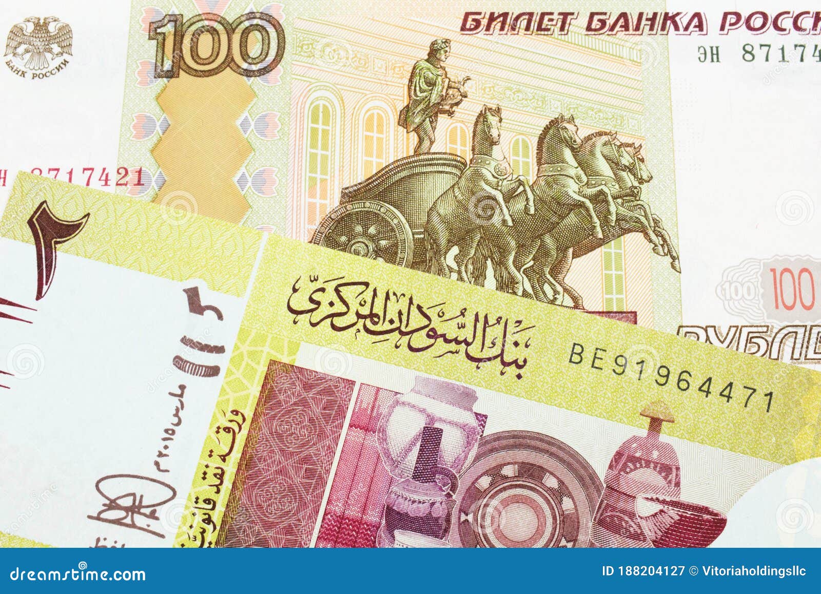 a russian one hundred ruble note paired with a green two pound bank note from sudan.