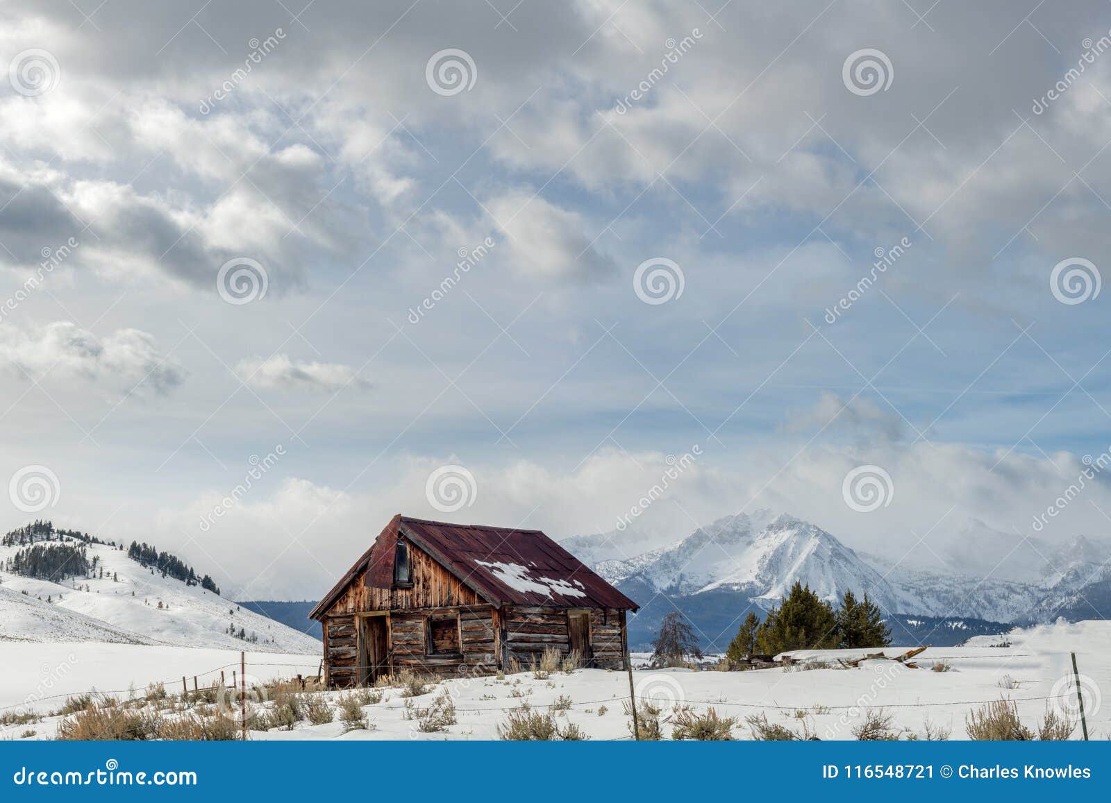 Rusted Roofed Log Cabin in the Idaho Wilderness Winter with Clouds in ...