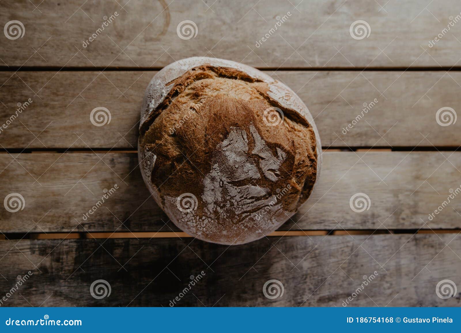 rustic bread, covered in flour, on wooden table