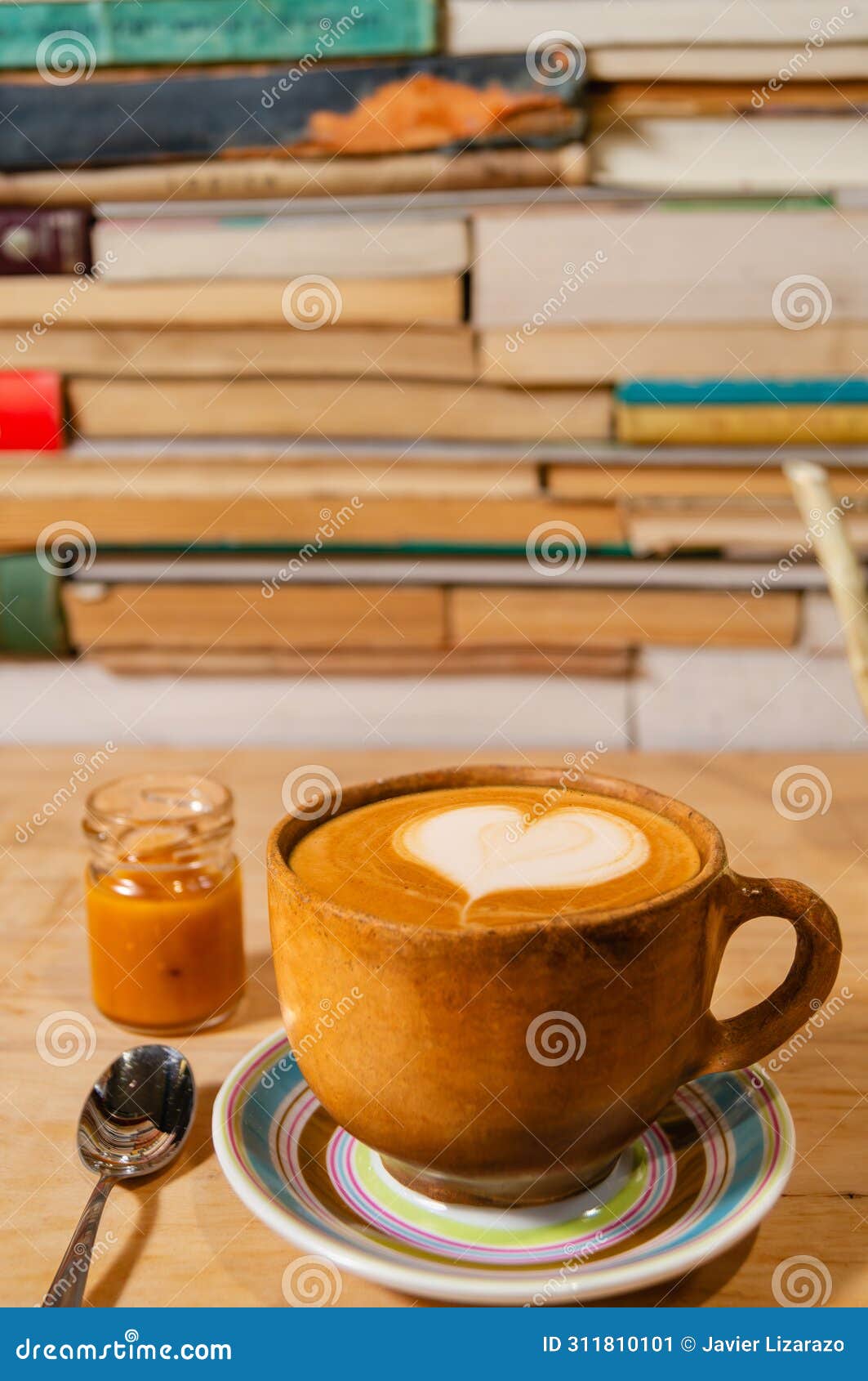 rustic ochre cappuccino mug with caramel and himalayan salt, d foam on plate, wood and book background - taza de capuchino r