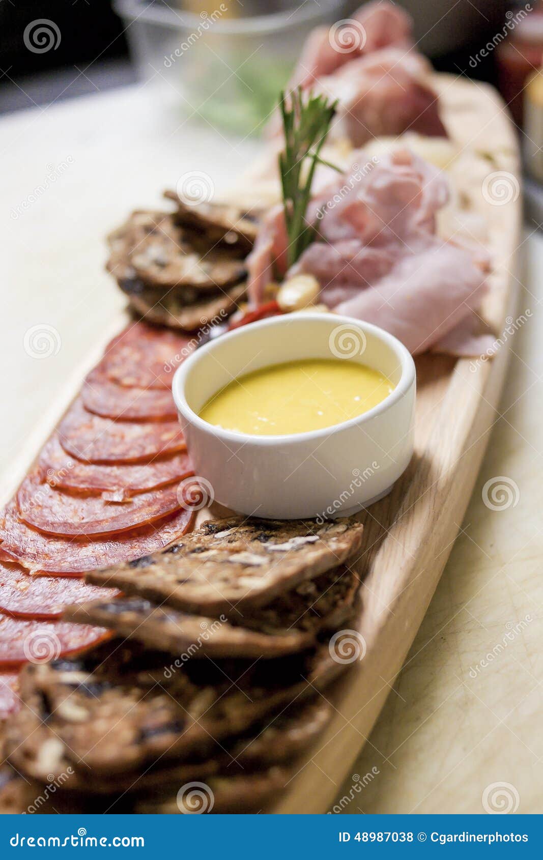 rustic presentation of a charcuterie board of sliced and cured m