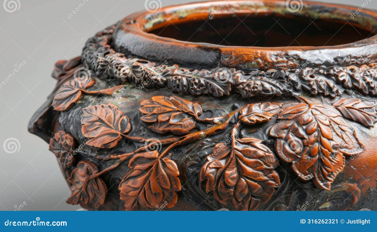the rustic textured surface of a coilbuilt pot adorned with natural motifs like leaves and branches.