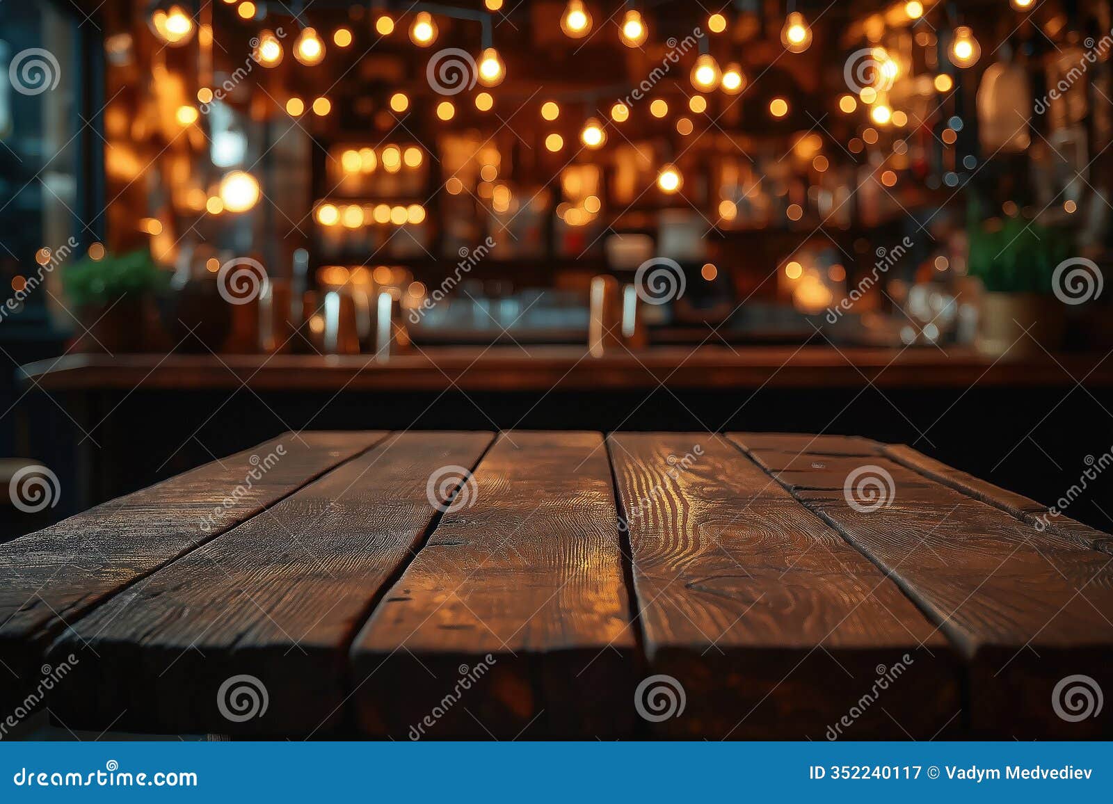 rustic wooden bar table in dimly lit interior. warm string lights create cozy ambiance in eatery. blurred background suggests pub