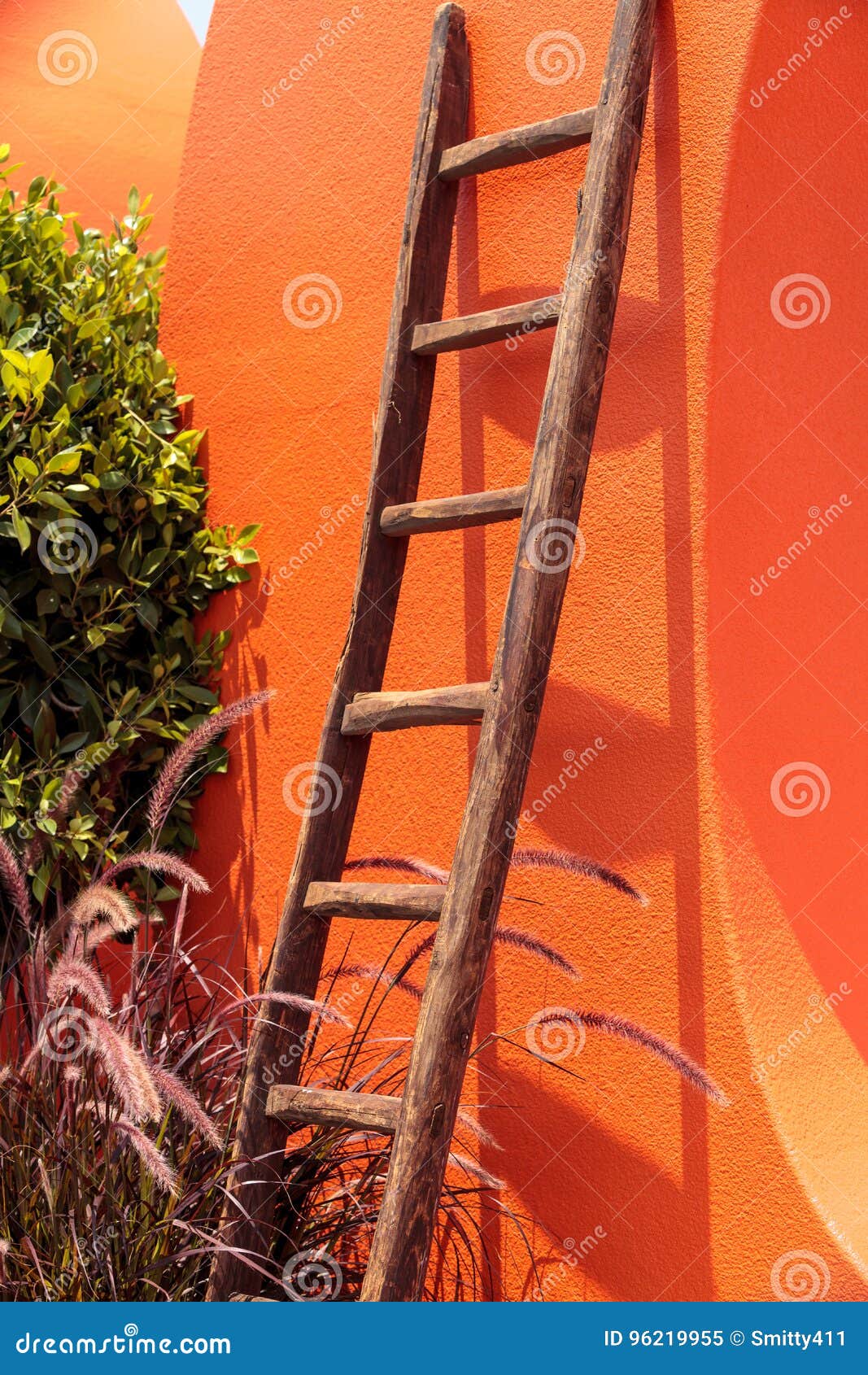 Rustic Wooden Ladder Against a Bright Orange Wall Stock Image Image