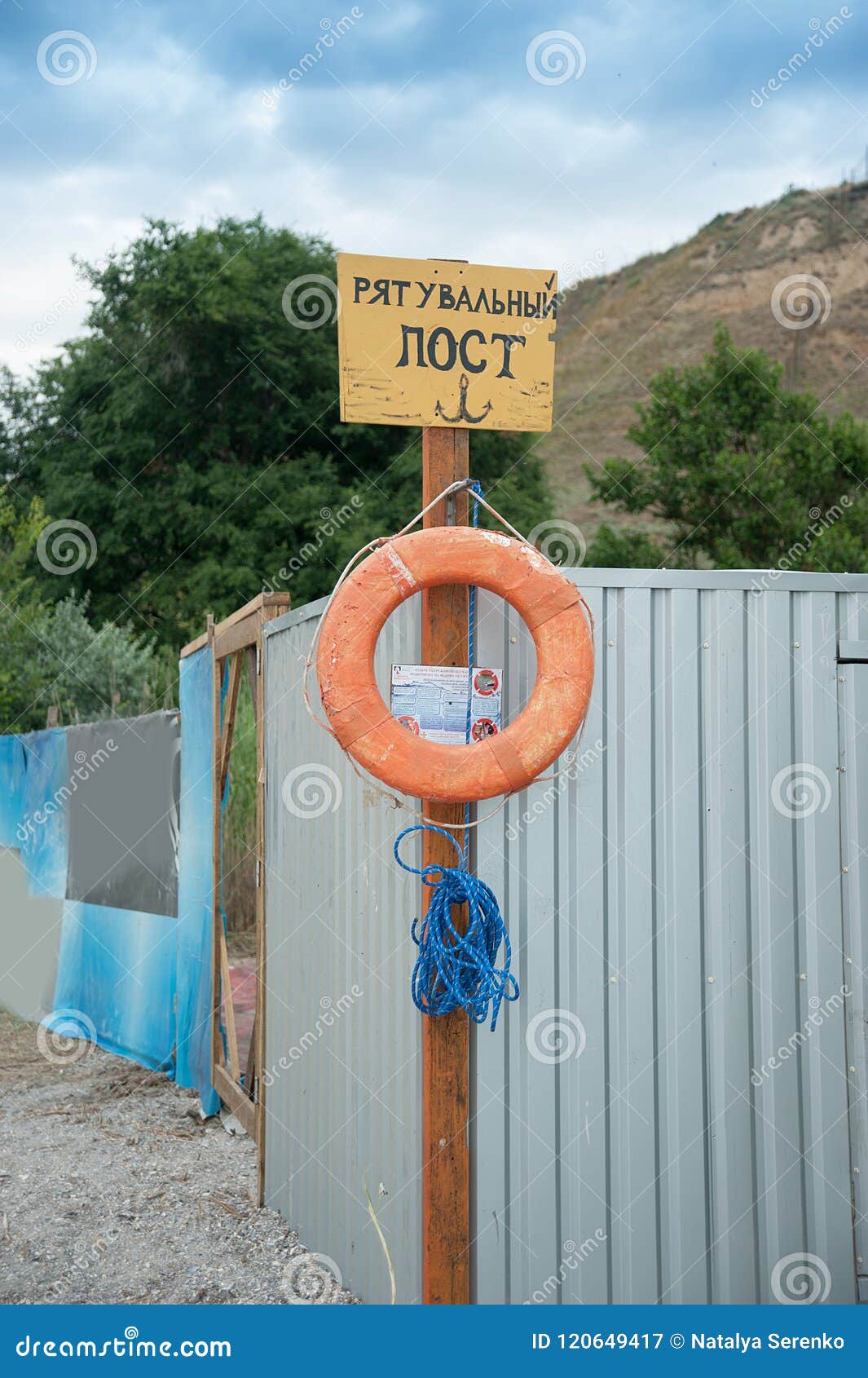 Räddningsaktionstation på stranden på solig dag Tecken på kusten Text i ukrainare: preserver för liv för räddningsaktionstolpe röd