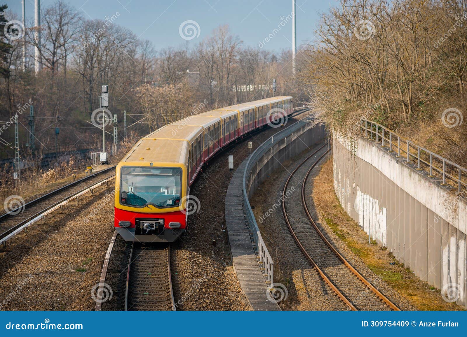 s bahn or suburban trains in berlin, germany. modern red and yellow train for commuting purposes, on station of messe sud on a