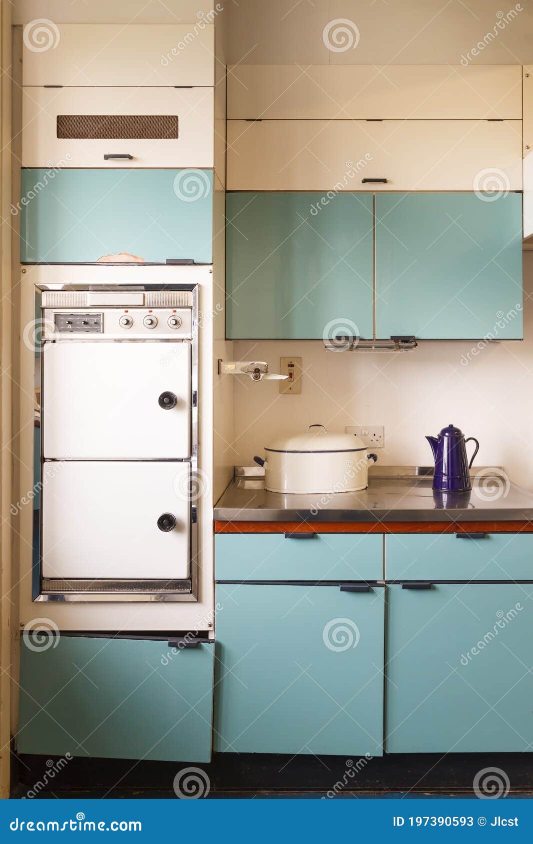 !960s retrofitted blue kitchen in disrepair with electric oven.