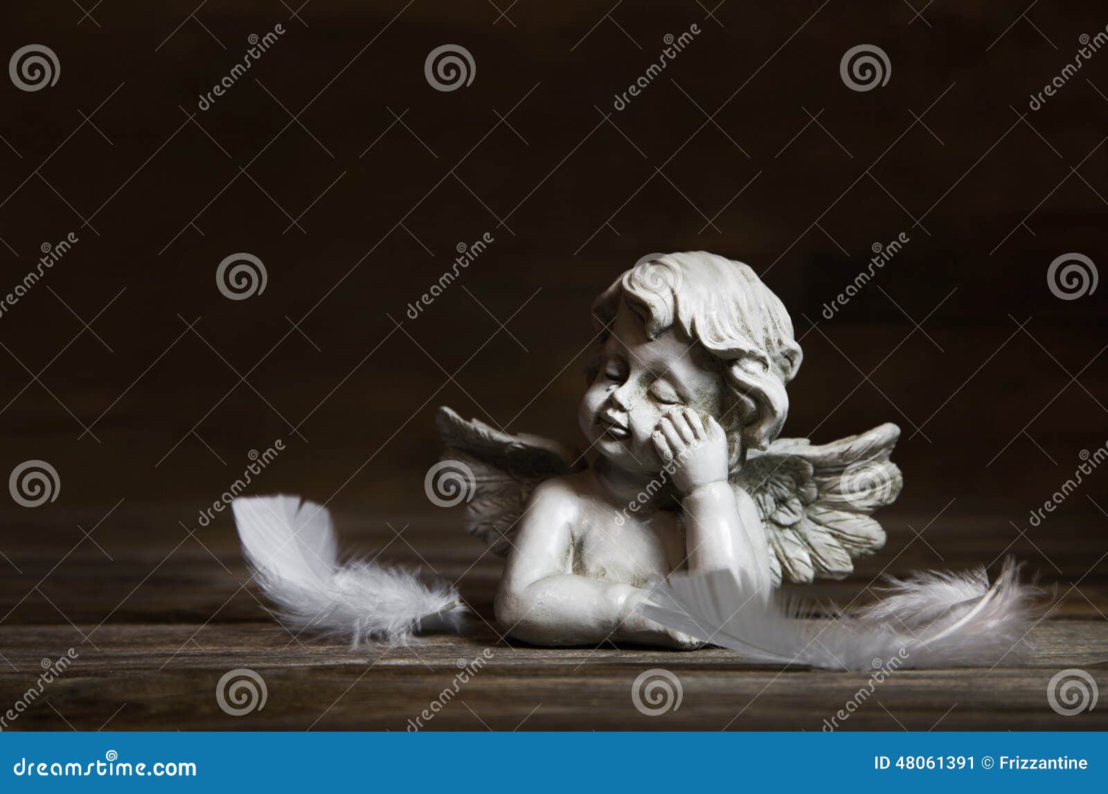 sad angel with white feathers on a dark background for bereavement.