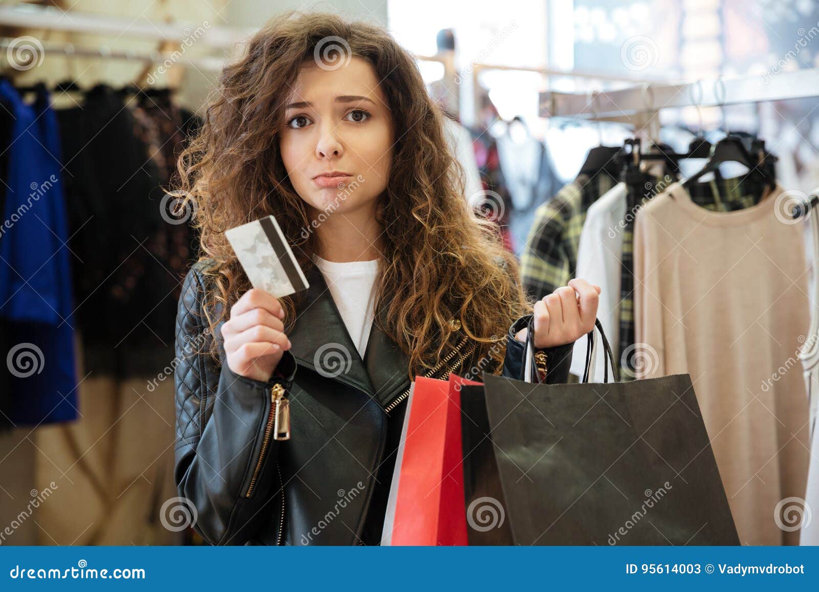 Sad Curly Young Lady with Shopping Bags Holding Debit Card. Stock Image ...