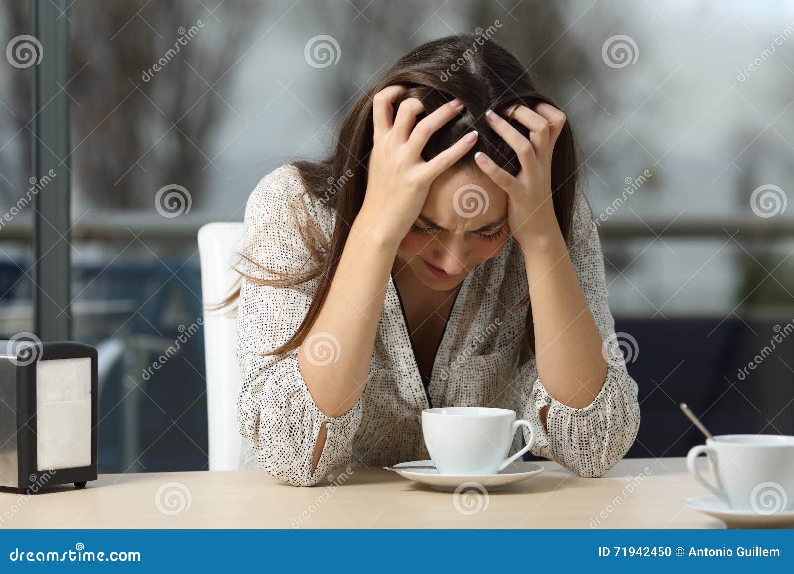sad and depressed woman alone in a coffee shop