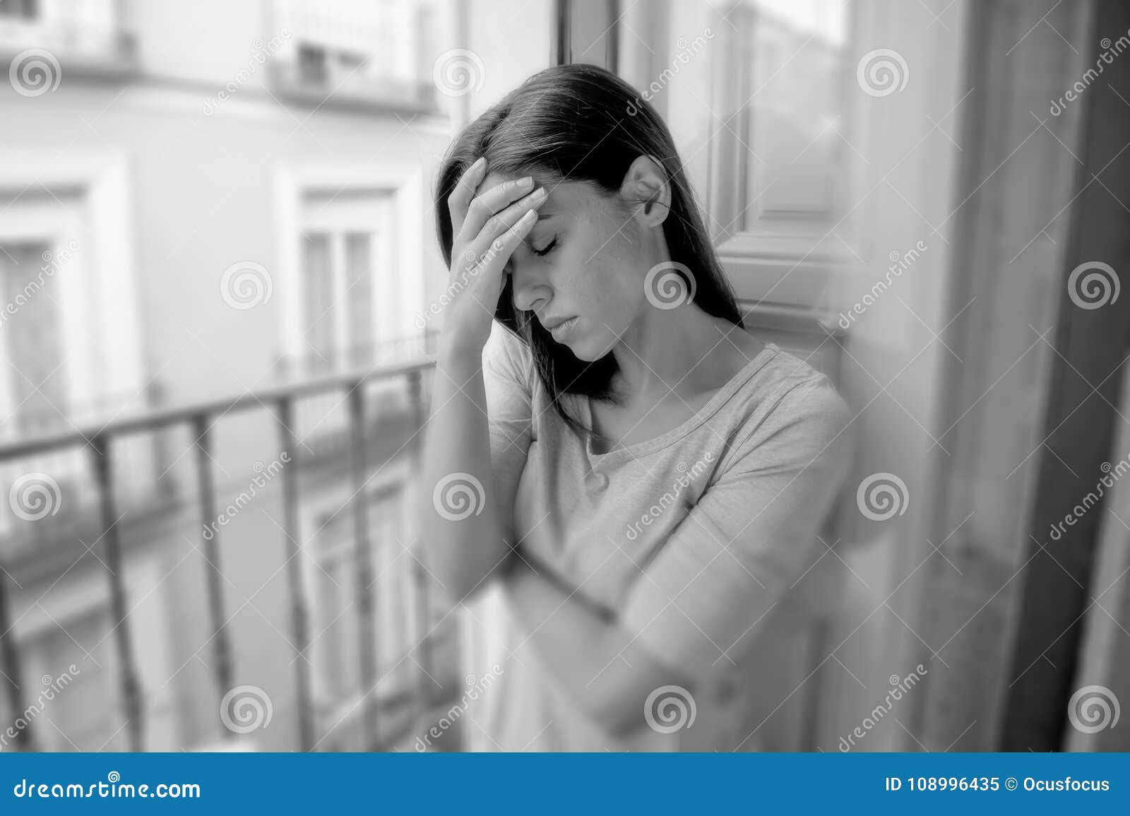 sad desperate hispanic girl at home balcony looking depressed suffering terrible migraine headache disorder or depression