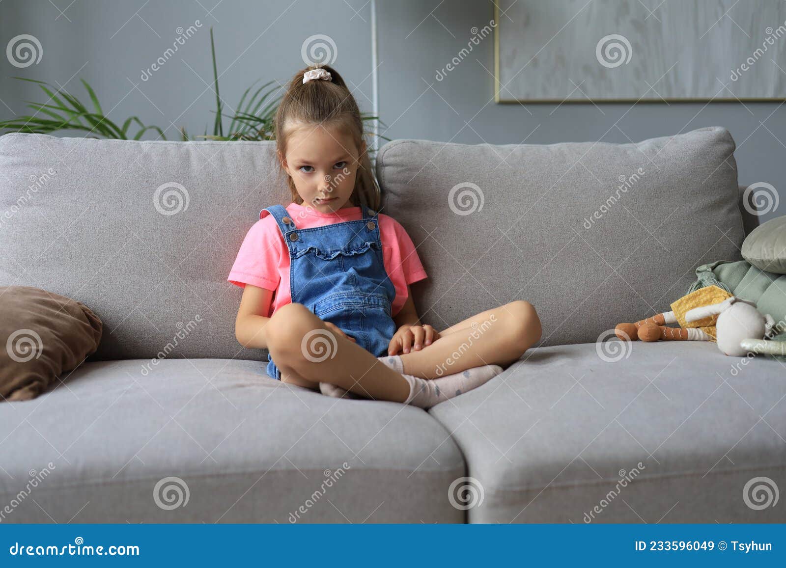 Sad Little Girl Sitting on Sofa Alone at Home. Stock Image - Image of ...