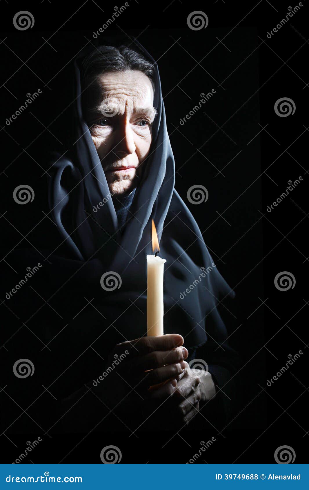 sad old woman senior in sorrow with candle