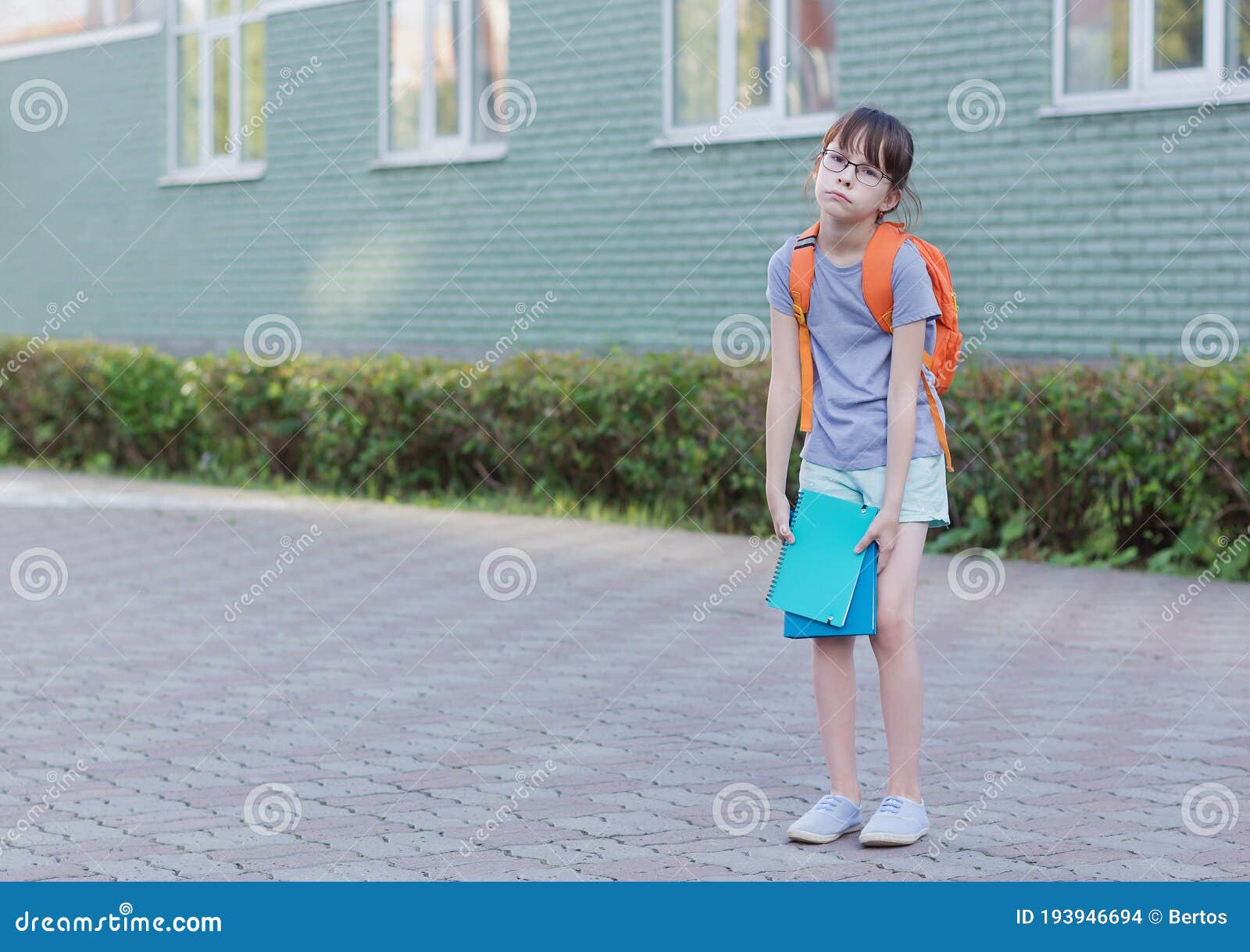 schoolgirl backs to school. portrait of tired child with backpack and notebook