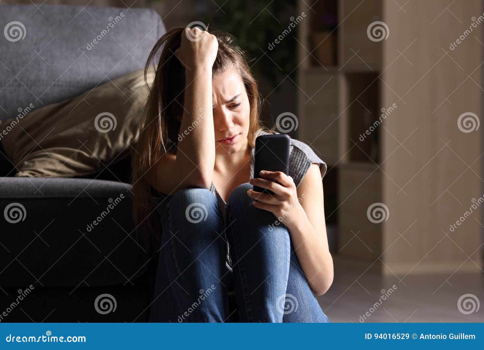 sad teen checking phone at home