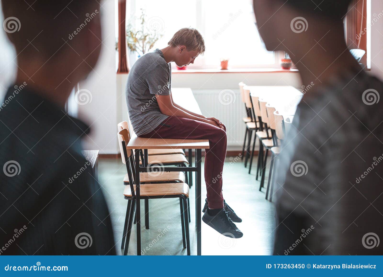 sad boy sitting alone at school, bullying among children concept
