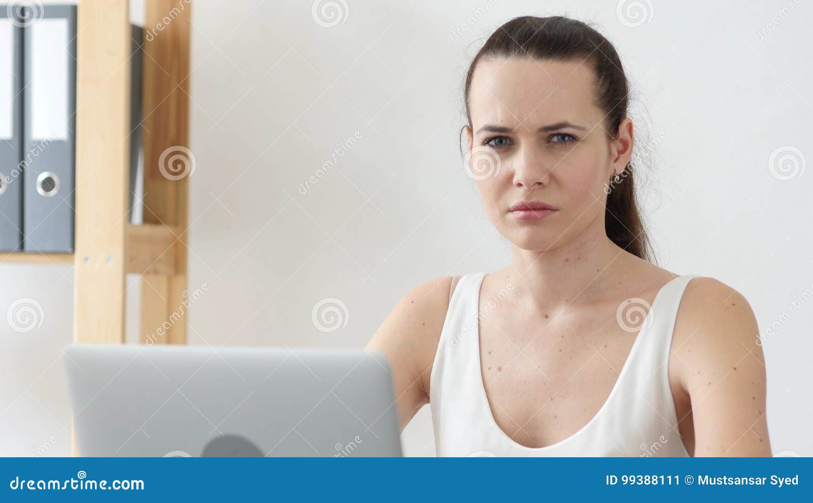 sad woman looking at camera at work in office