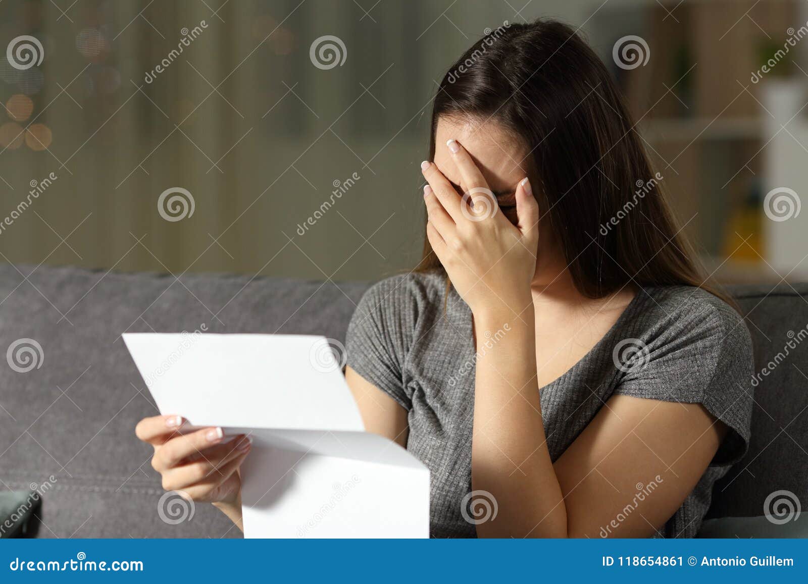 sad woman reading a letter in the dark