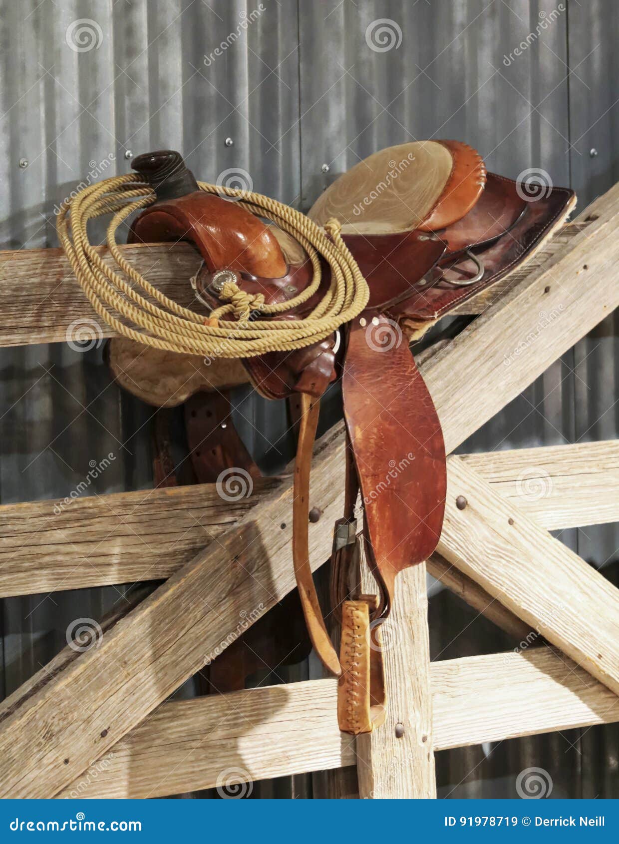 a saddle and a lariat on a gate