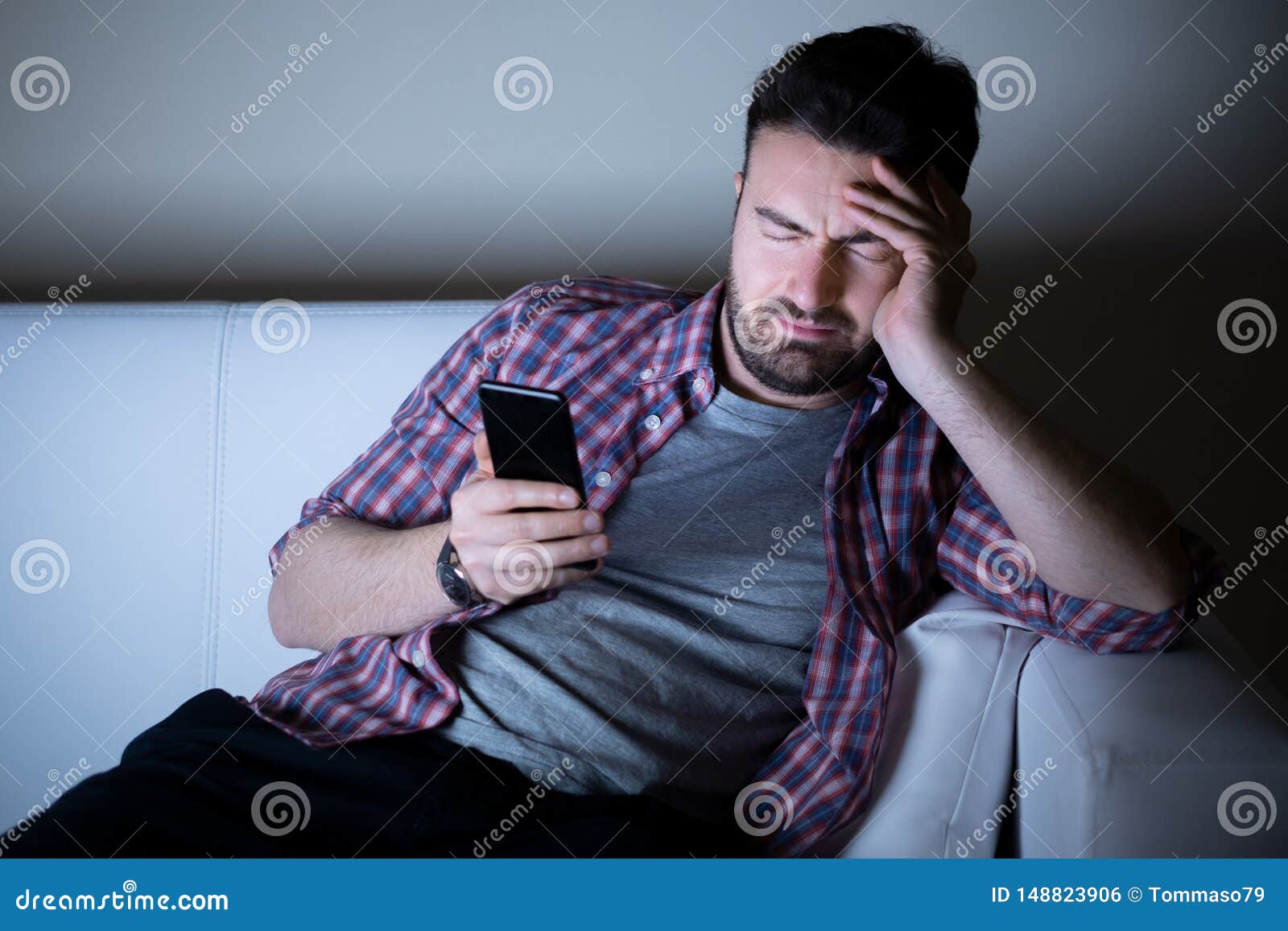 Man Feeling Depressed Using Phone At Night Stock Photo