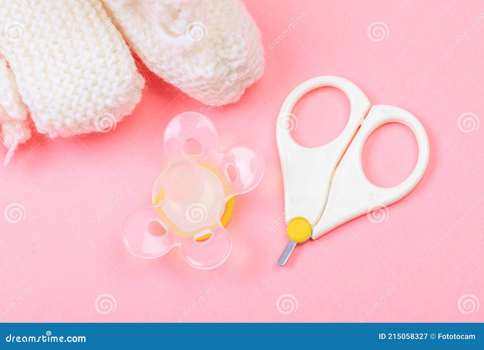 Safe Scissors, Soother and Booties for Babies on Pastel Pink Background