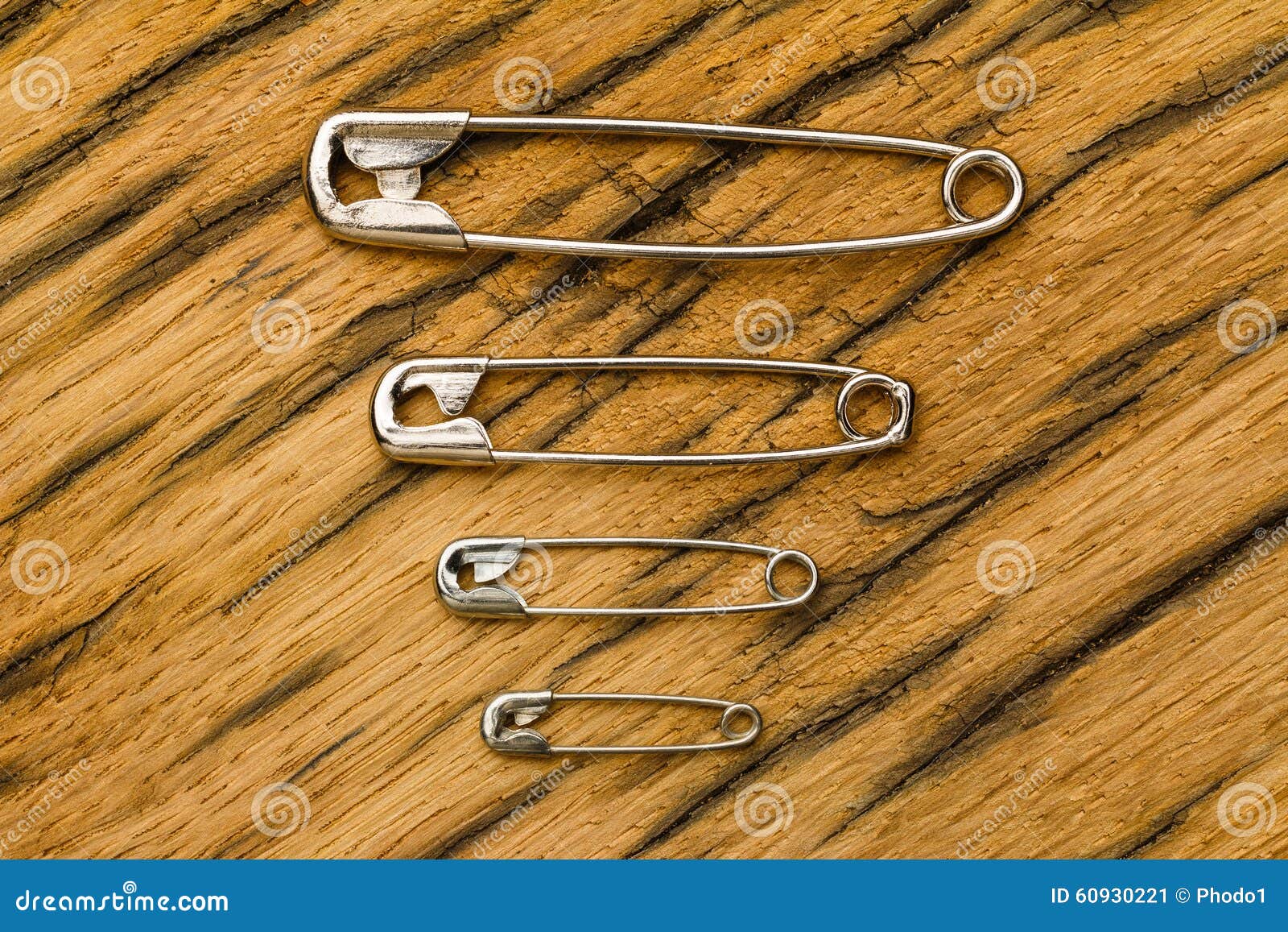 Safety Pins Small To Big on Wood Stock Image - Image of design
