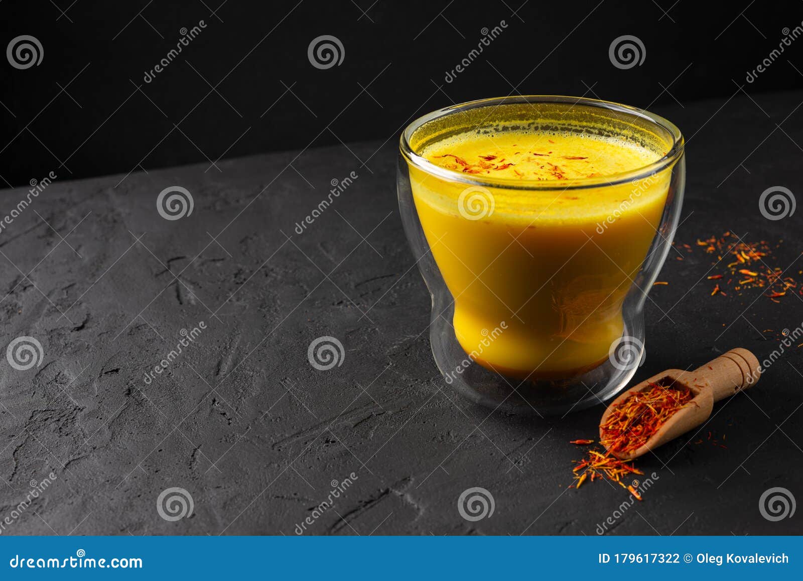 Saffron Latte in a Glass Cup on a Black Concrete Background, Wooden ...