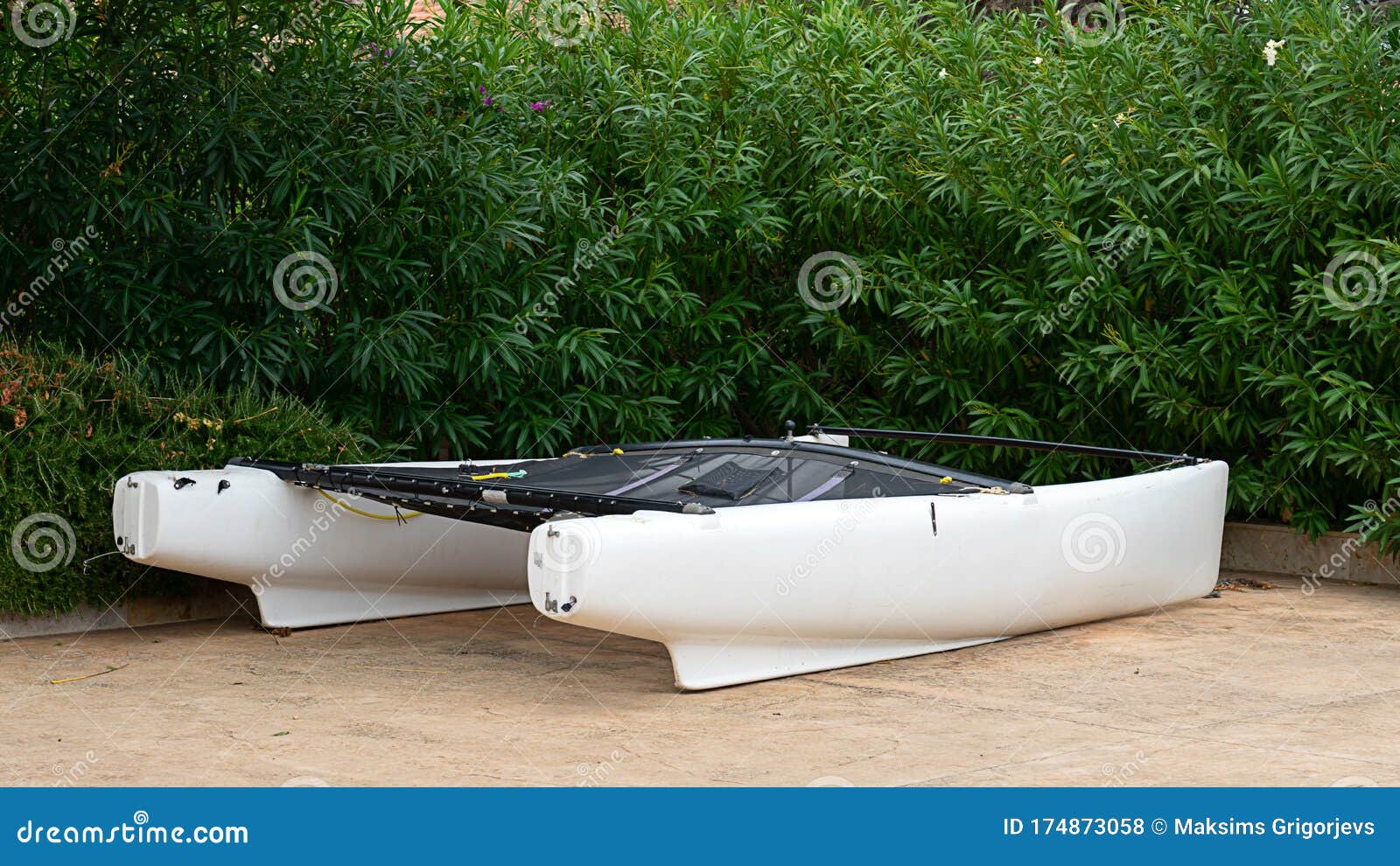 Sail Boat and Catamaran, Kayak Standing in Tropical Greenery Stock
