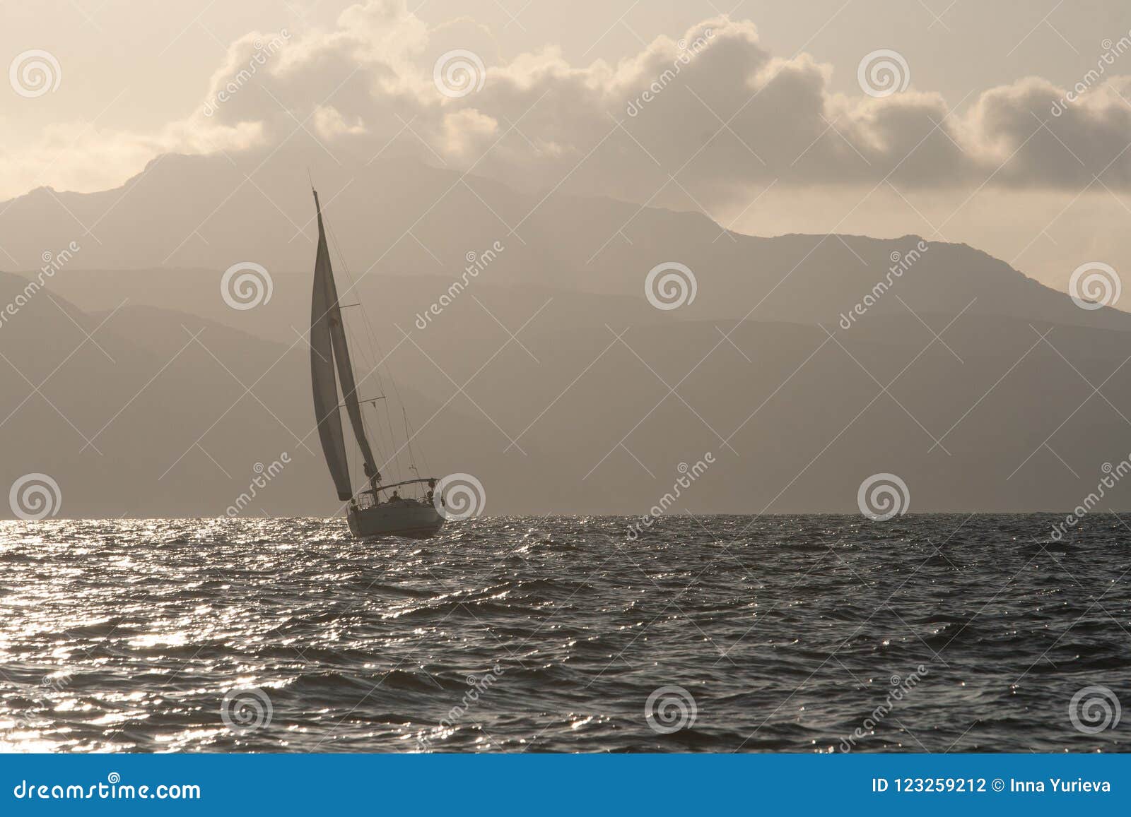 sailboat on a stormy sea against the rocky shore