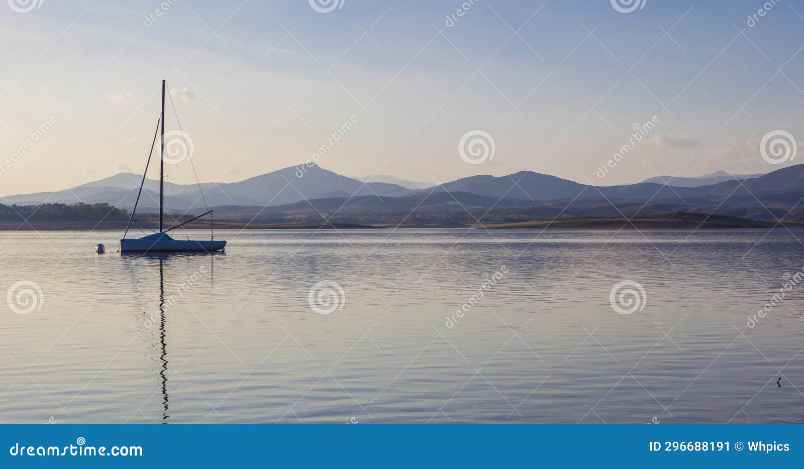 sailing boat anchored on the shore of the gabriel y galan reservoir