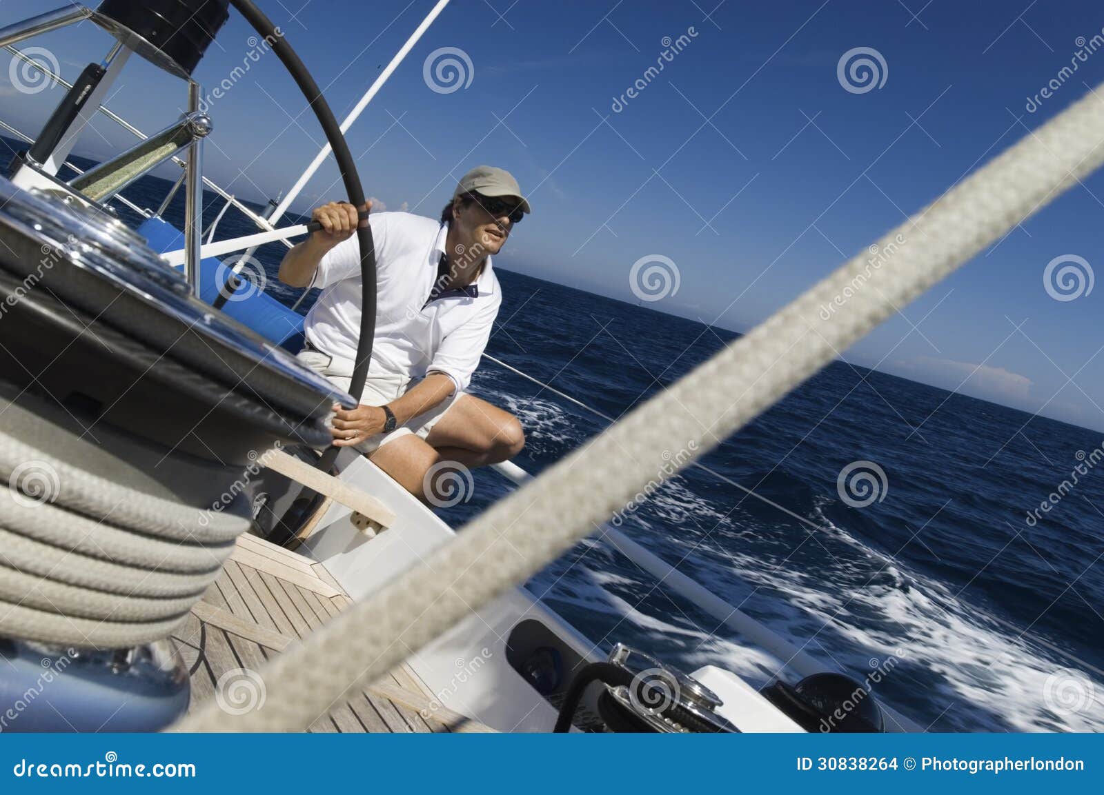sailor at helm of sailboat