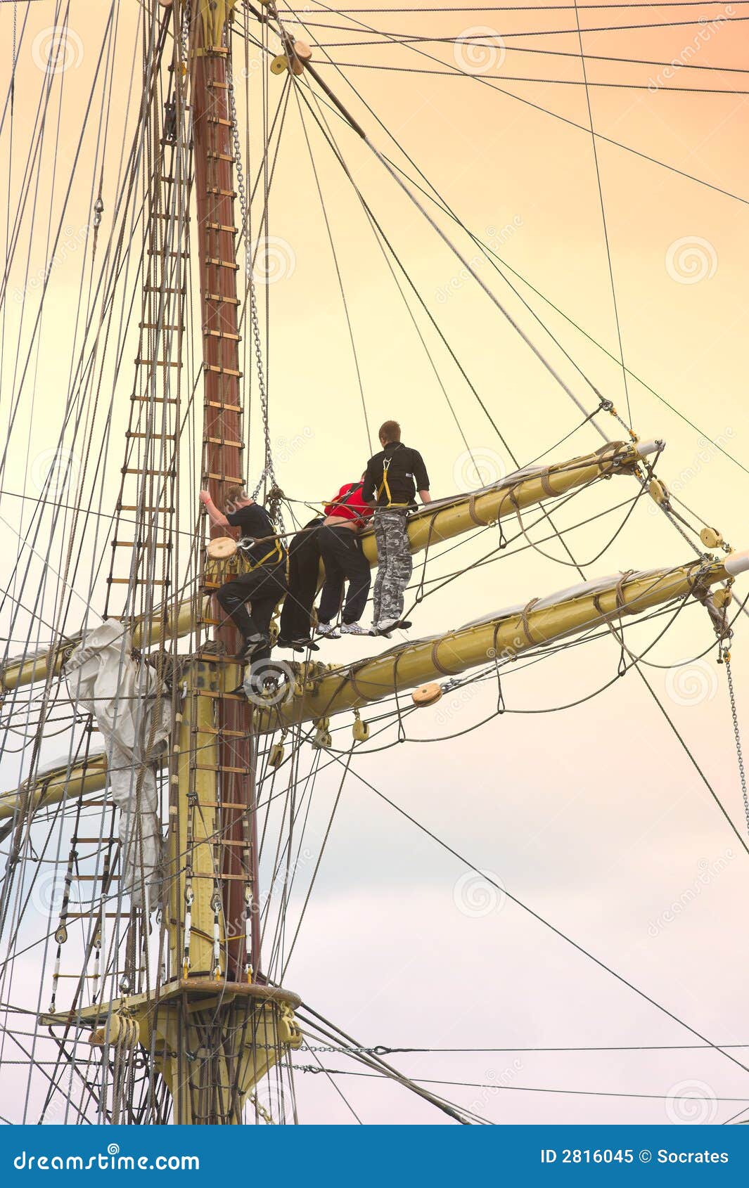 sailors on sailboat rigging