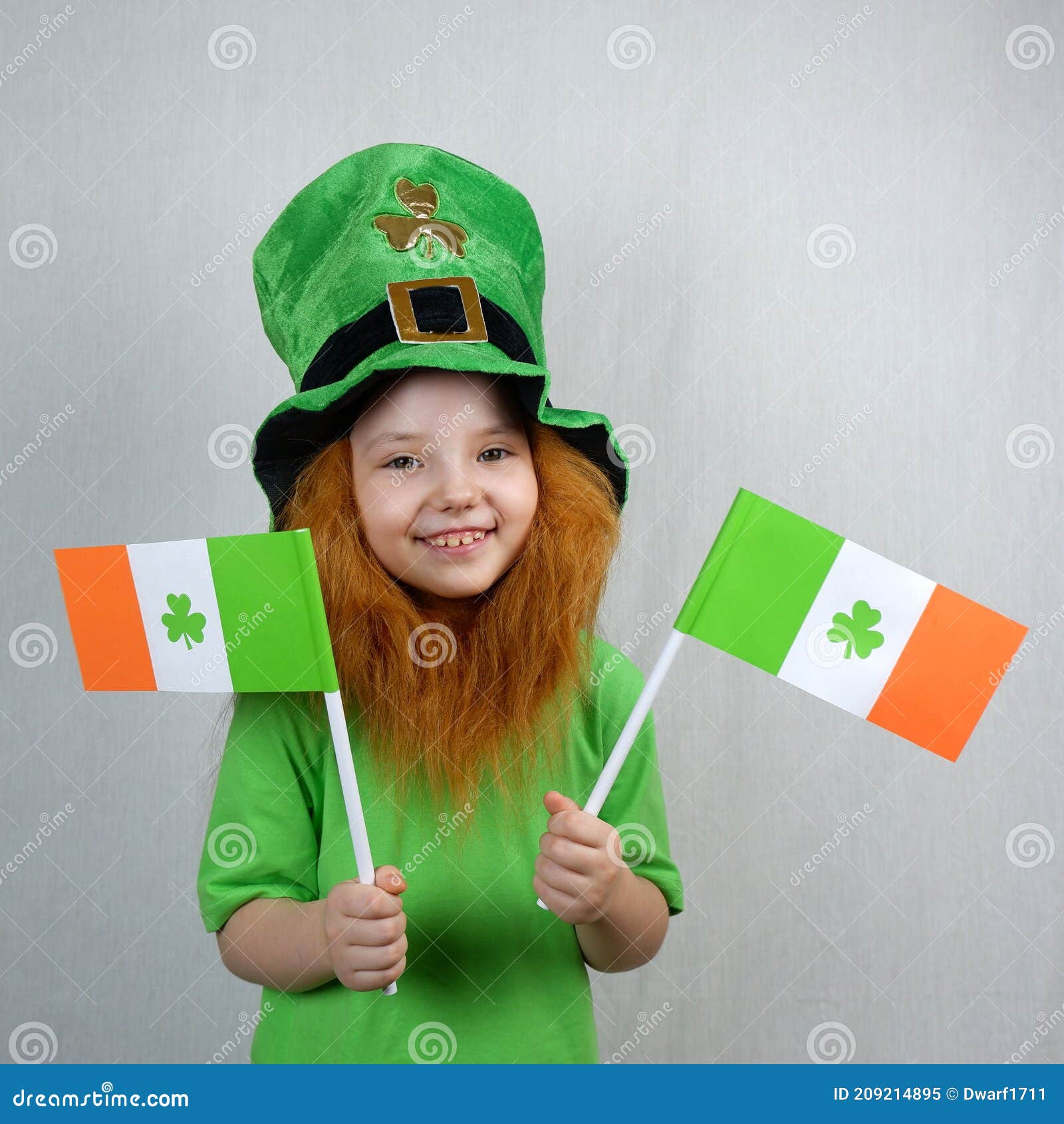 saint patricks day. endearing smiling little girl with decorative red beard, dressed in green, in leprechaun's hat