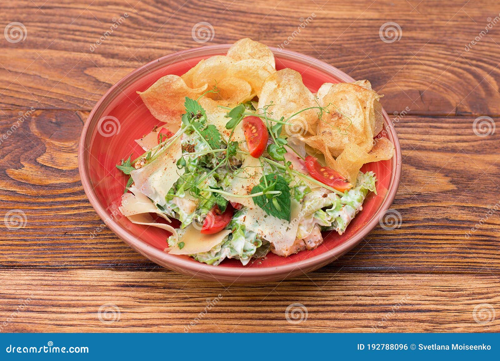 Salad with Chips, Cheese and Herbs in a Plate on a Wooden Table Stock