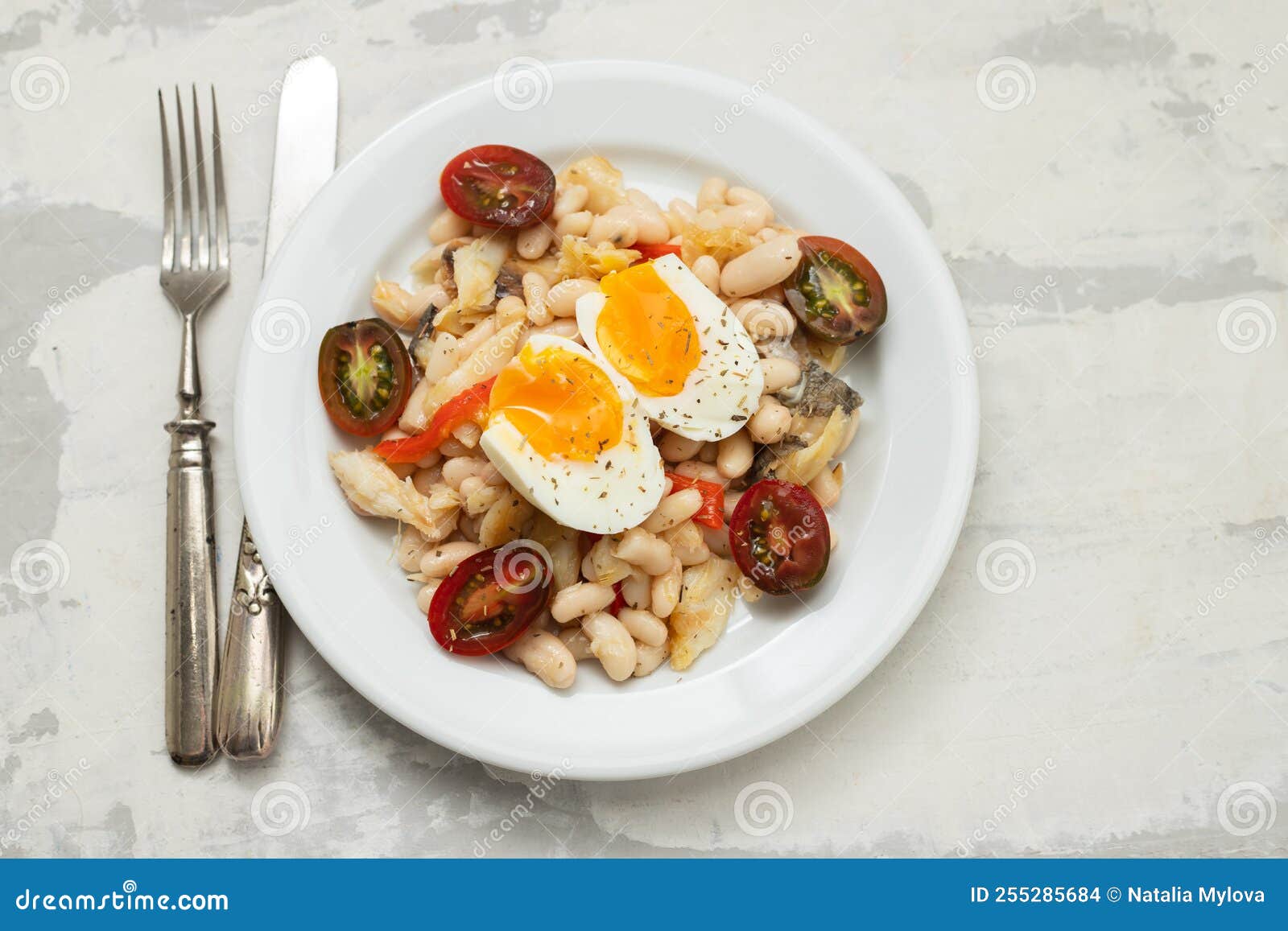 Salad with Fried Cod Fish and White Beans on the Plate. Stock Photo