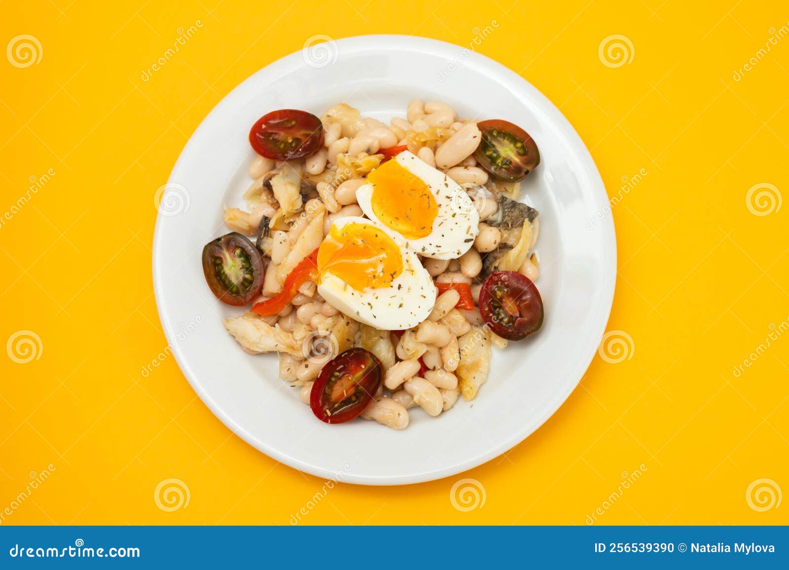 Salad with Fried Cod Fish and White Beans on the Plate. Stock Photo