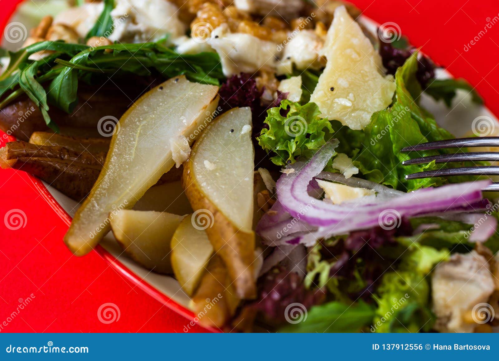 salad with pear, lettuce, walnut, cheese and onion on red