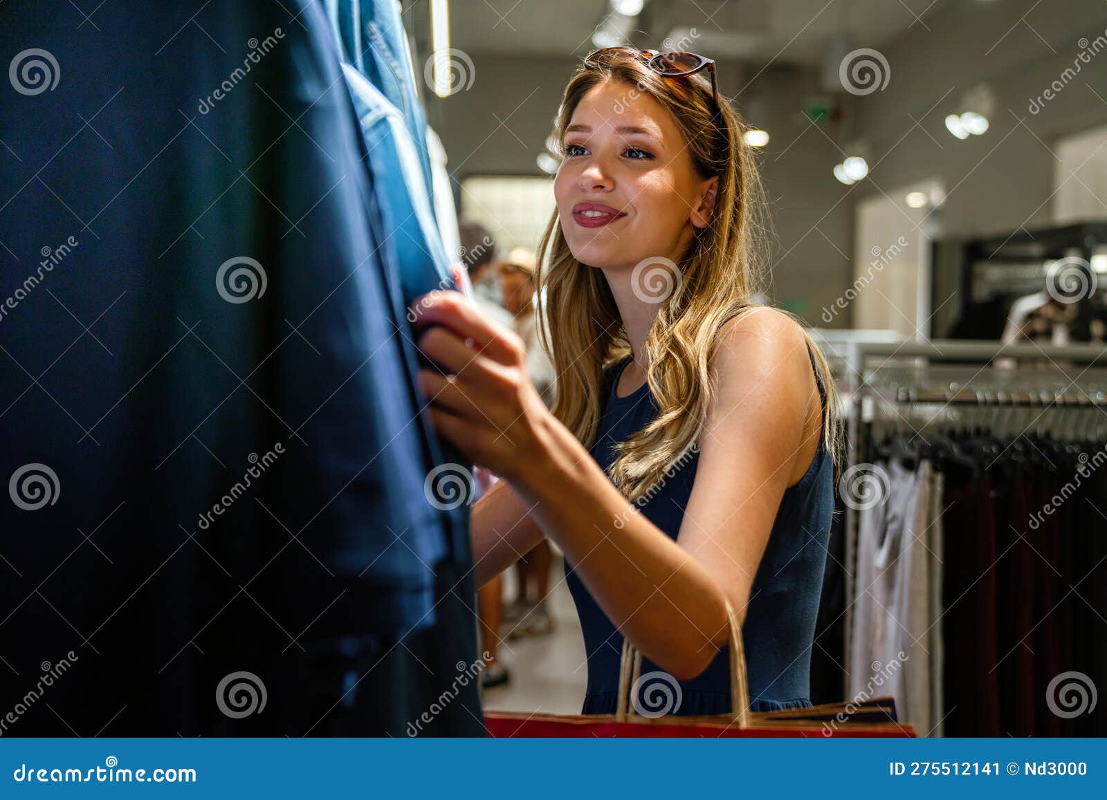 Young attractive woman buying clothes in mall Stock Photo by nd3000