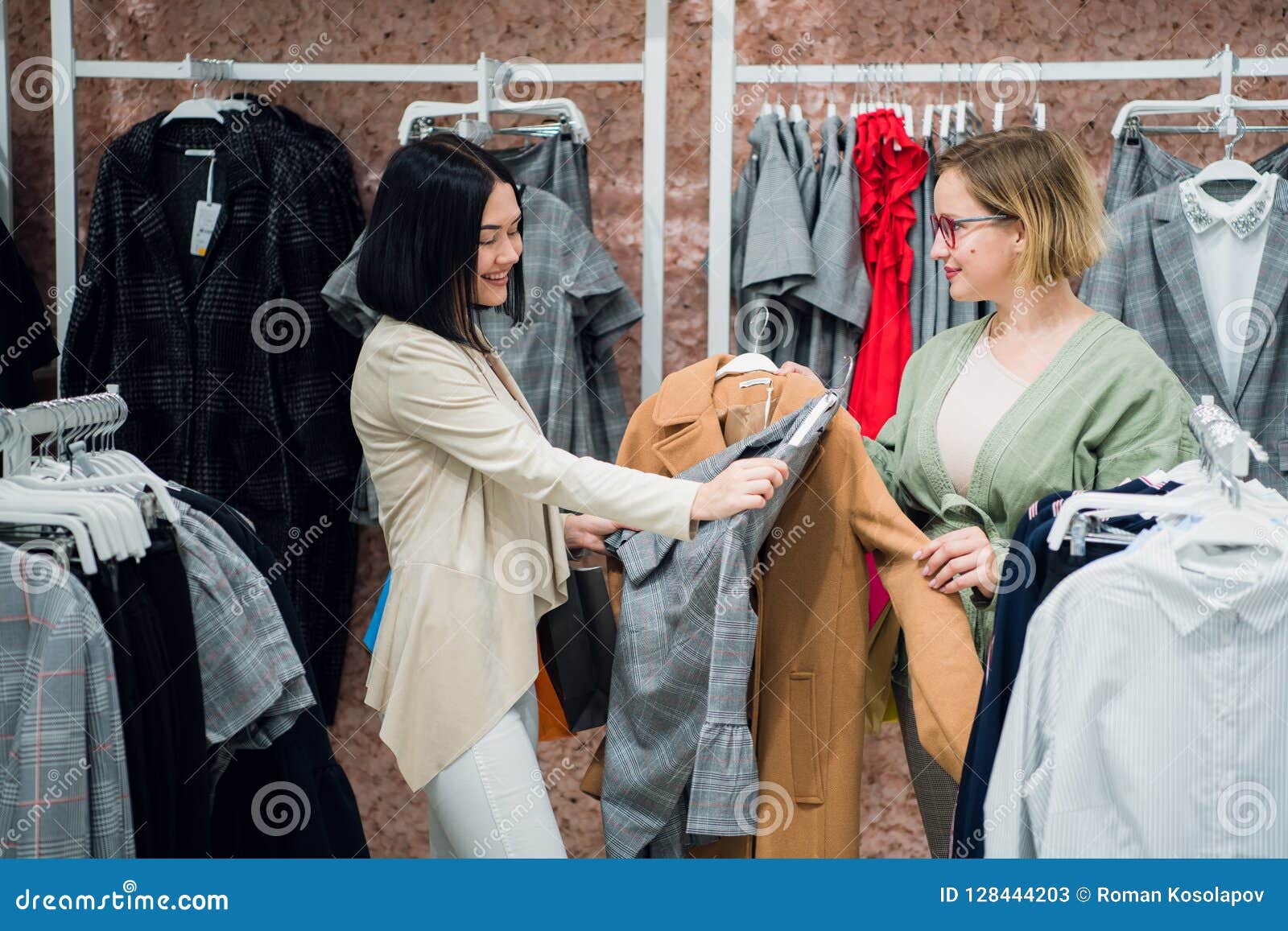 sales consultant helping chooses clothes for the customer in the store. shopping with stylist concept. female shop