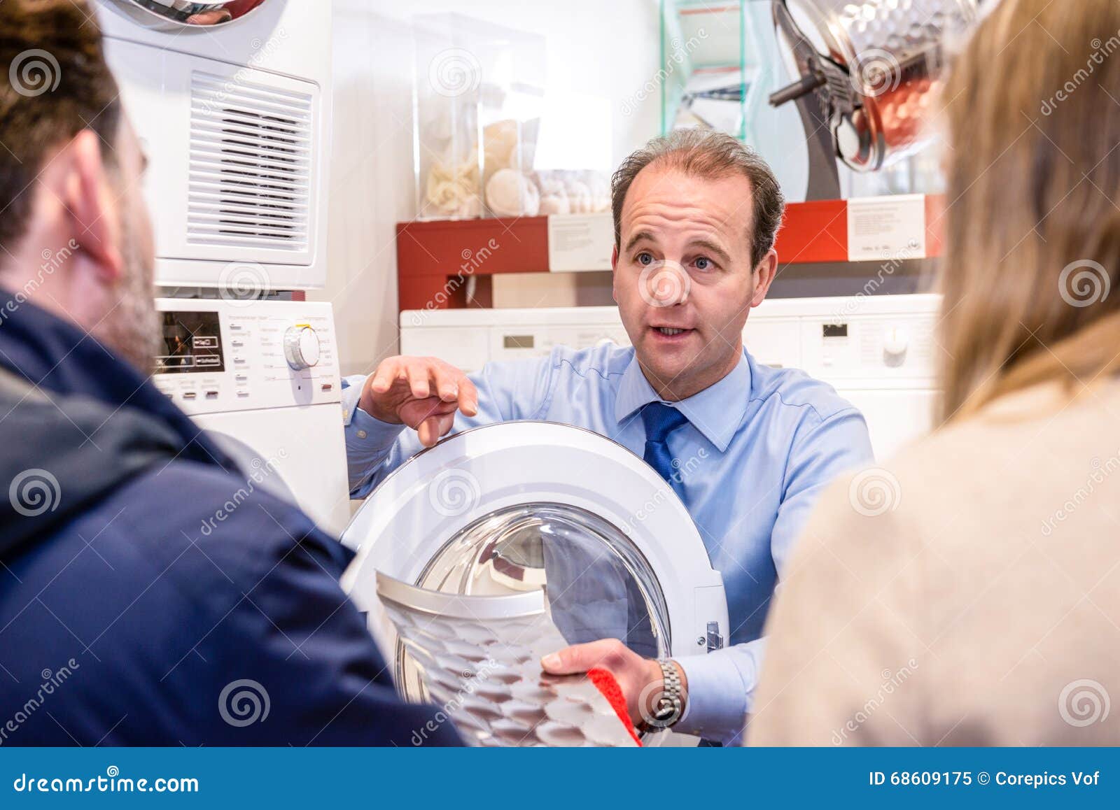 salesman explaining product to couple in hypermarket