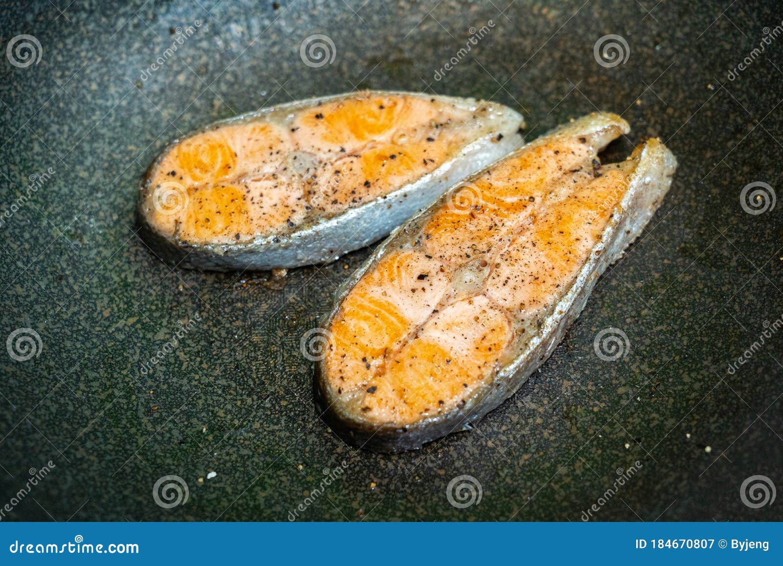 Salmon frying in a pan stock image. Image of herbs, black - 184670807