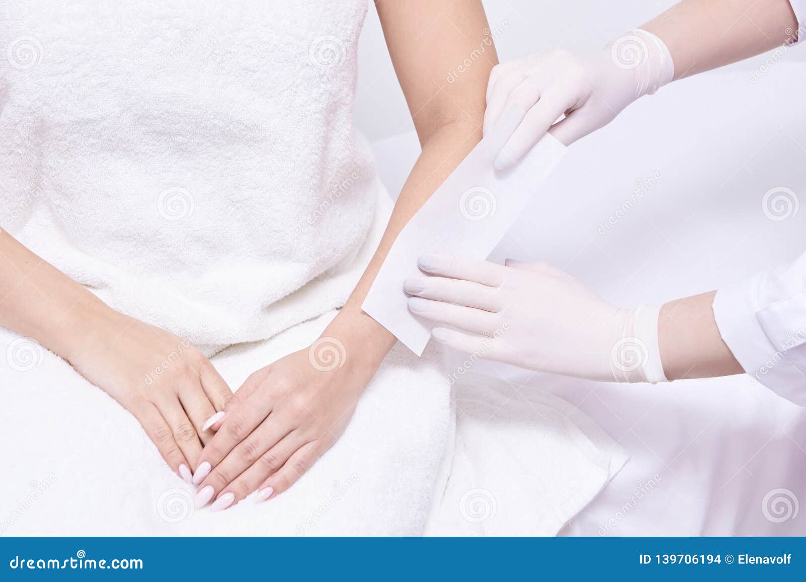 salon forearm shugaring procedure. doctor arm cosmetology salon