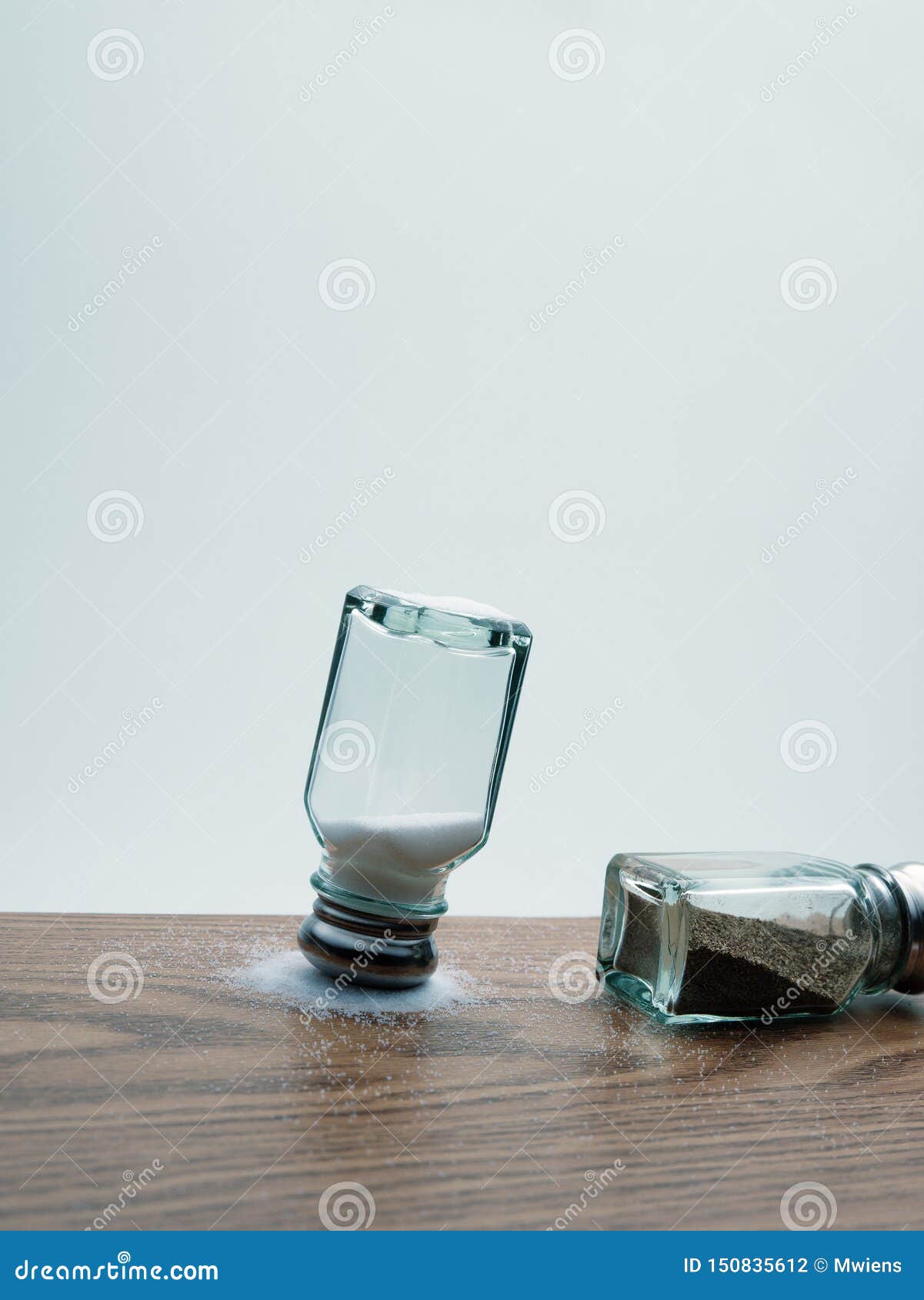 Upside Down Salt Shaker on Spilled Salt with Tipped Over Pepper Shaker
