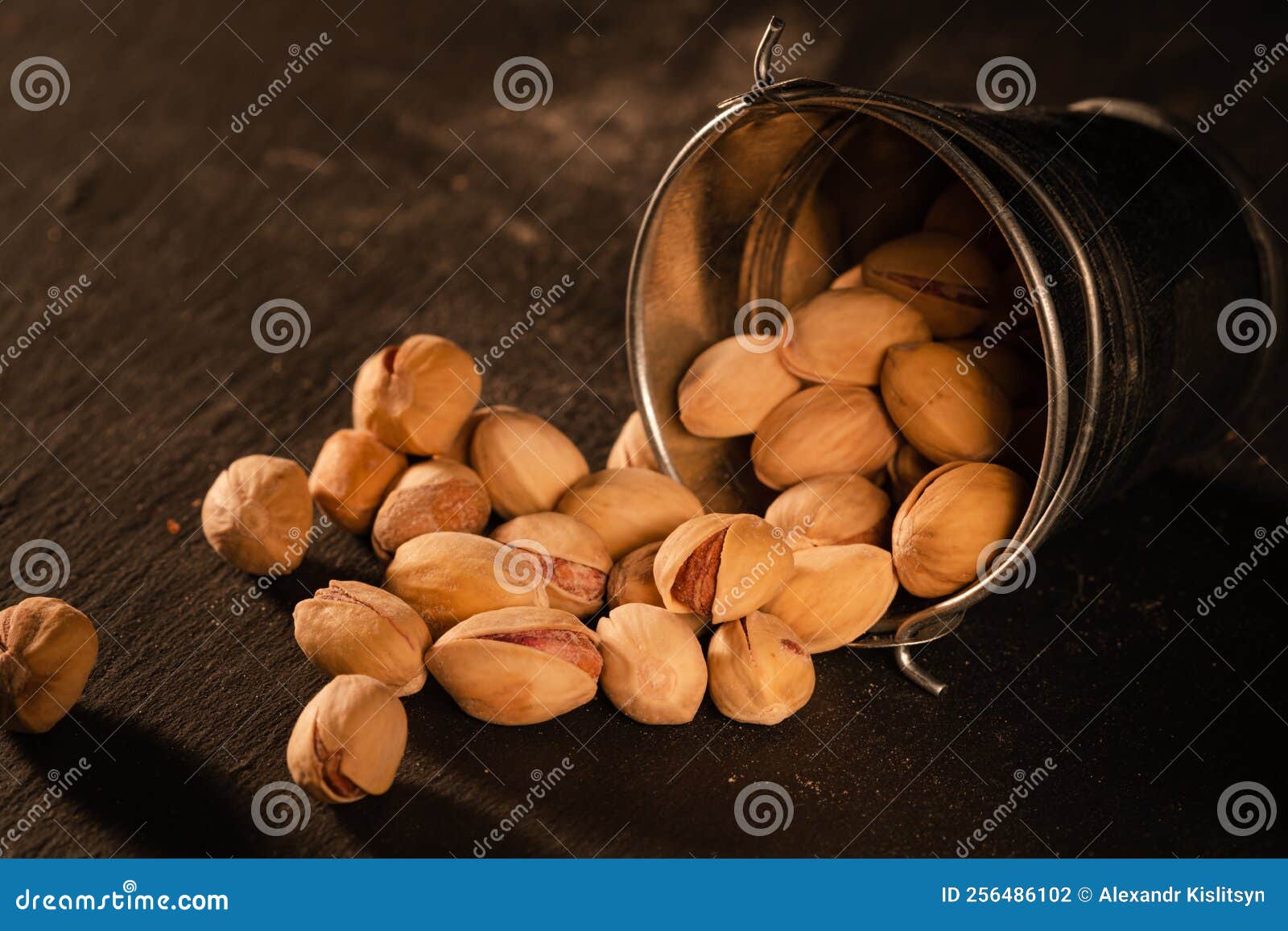 Salted Pistachios Scattered on the Table from a Fallen Bucket Stock