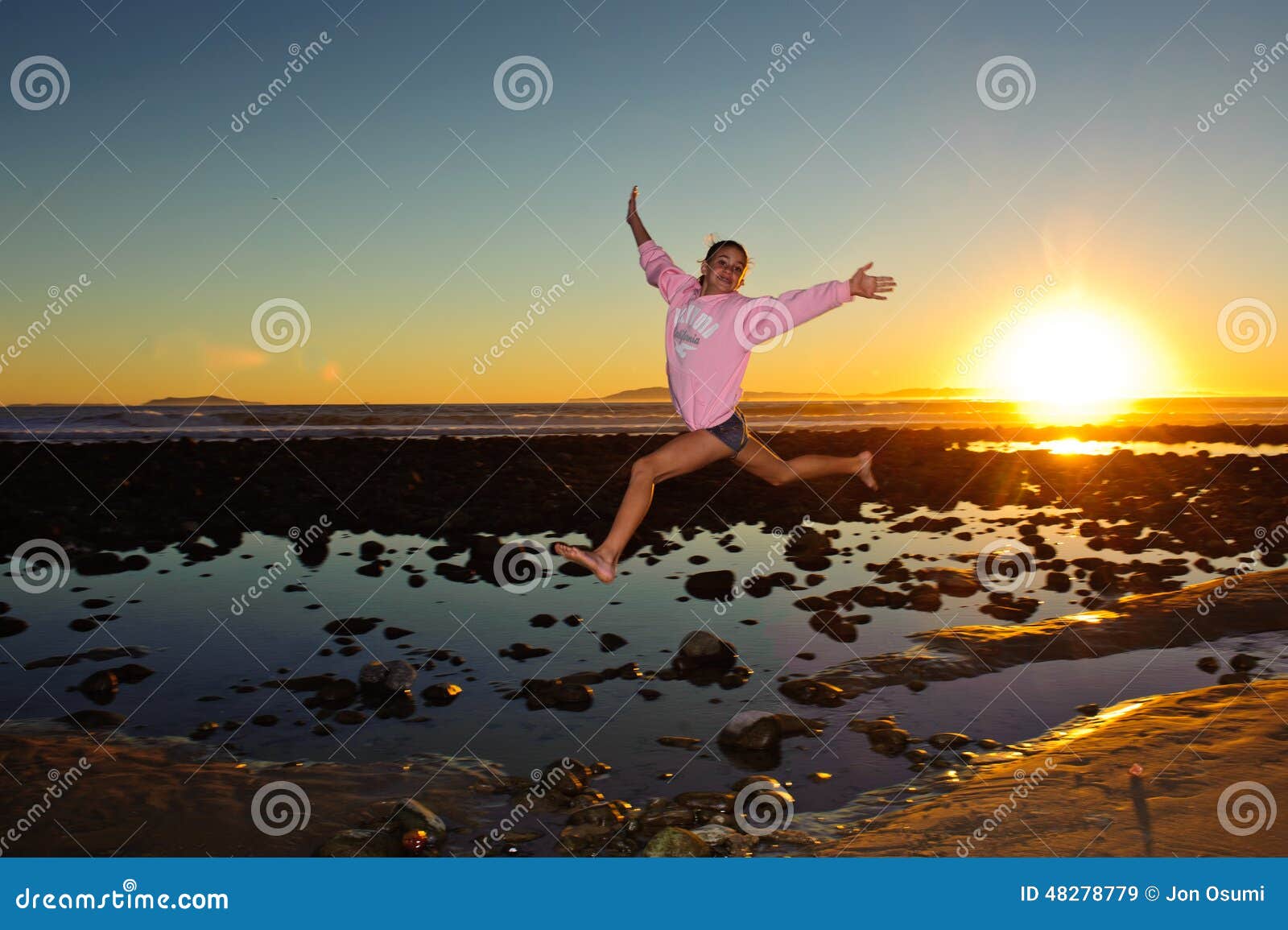 Salto Sobre La Piscina De La Marea Imagen de archivo Imagen de sunset