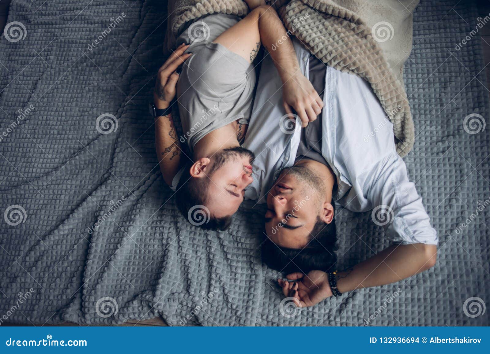 Handsome Sleepy Man with Bristle Kissing Good Night Male Partner Lying in Bed Stock Photo photo