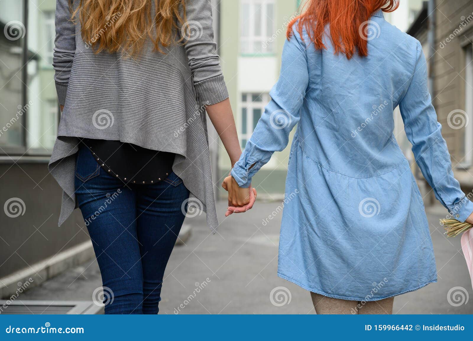 Same Sex Relationships Happy Lesbian Couple Walking Down The Street Holding Hands The Backs Of