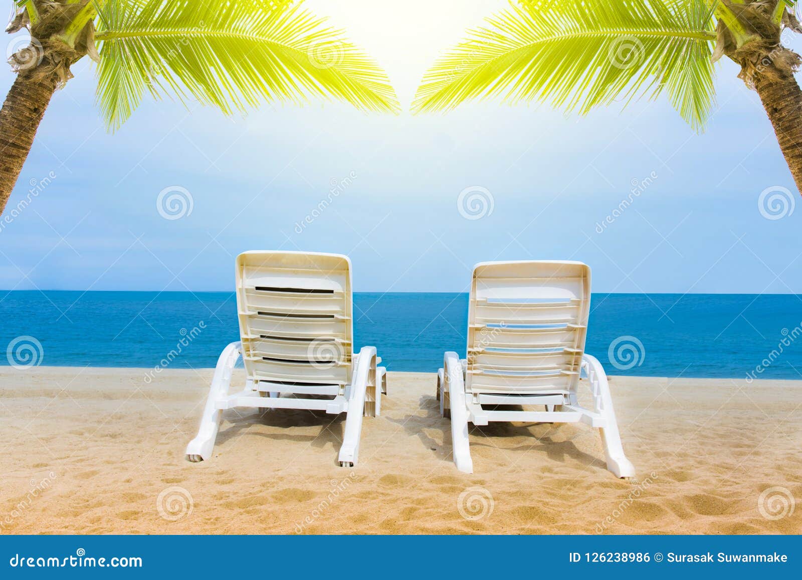 Sand Beach With Coconut Trees With Two Chairs And Bokeh